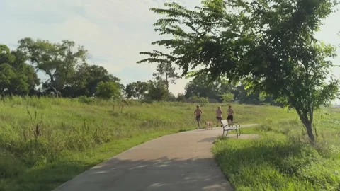 Three young men running through Exploration Green on a summer morning Video stock 336460238