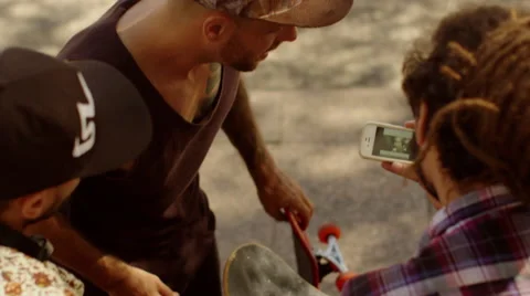 Three young men watching a clip on cellphone Stock Footage 61274108