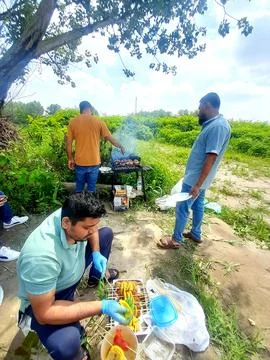 Three young men working for BBQ party. Barbecue Party in outdoor place Fotos de archivo