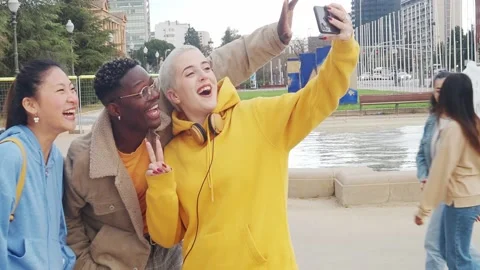 Three young multiethnic tourists making a selfie and video call in a big city. Stock Footage 171157980
