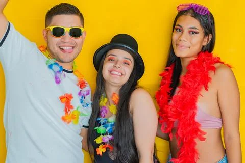 Three young multiethnics, smiling and posing happily, dressed in carnival c.. Stock Photos