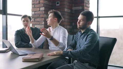 Three young office workers looking disappointed at their laptop screen after a Stock Footage 305406171
