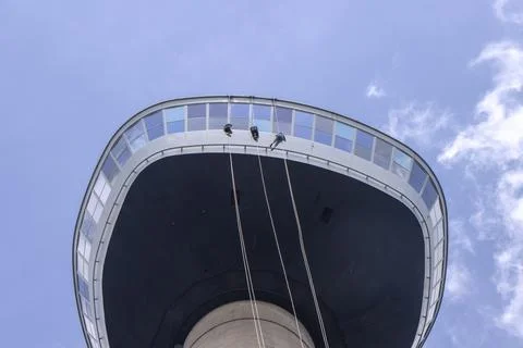 Three young People abseiling down the Eromast tower in Rotterdam Stock Photos