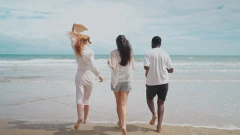 Three Young People from Different Backgrounds Running Towards Along the Beach Stock-Footage 314063382