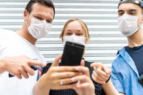 Three young people of different ethnicities with protective masks on their fa Stock Photos