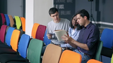 Three young people discussing notes after educational training Stock Footage 105190996