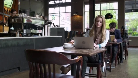 Three young people sitting in a coffee shop 動画素材 83412508