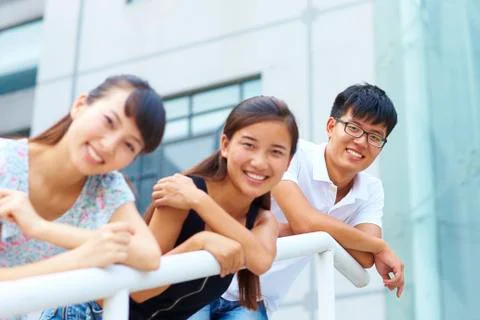 Three young people smile at camera Stock Photos