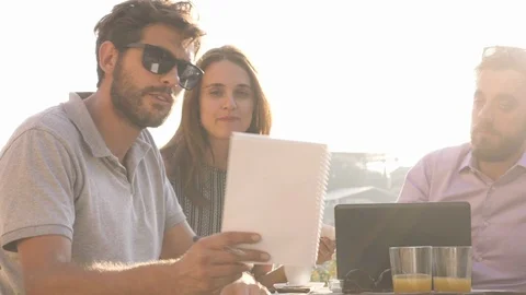 Three young people working together on a project with laptop and tablet Stock Footage 121378655
