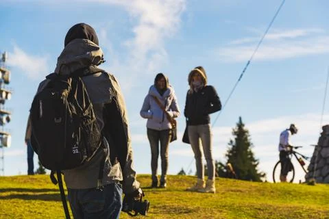 Three young persons at the peak of the mountain making photos. Stock Photos
