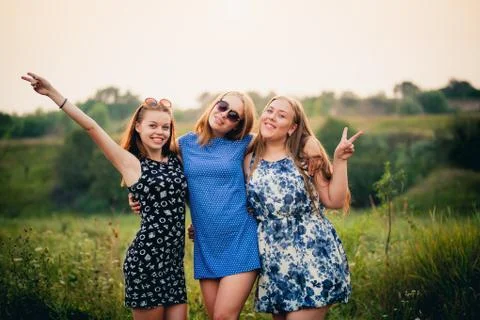 Three young student posing for the camera at sunset in summer. Stock Photos