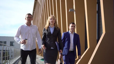 Three young stylish man walking down the street in business suits and talking Stock Footage 112632344