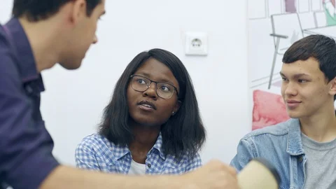 Three young teammates having friendly talk at coffee break Stock Footage 105188258