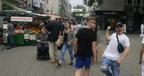 Three young wanton boys making fun in shopping street in Germany, tracking shot Stock Footage 90546835