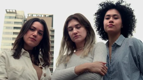 Three young women looking at the camera seriously in a city. Empowered Women Stock Footage 247419616