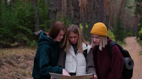 Three young women reading a map in the fall woods. Stock Footage 254289597