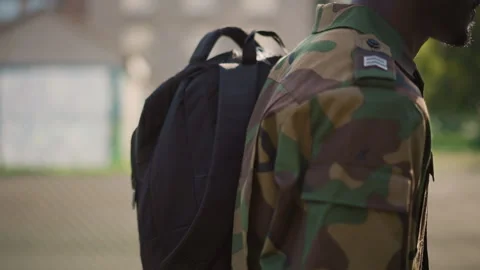 Threequarter View Soldier With Backpack Walking Along Fence Line, Camo Sleeve Stock Footage 329498992
