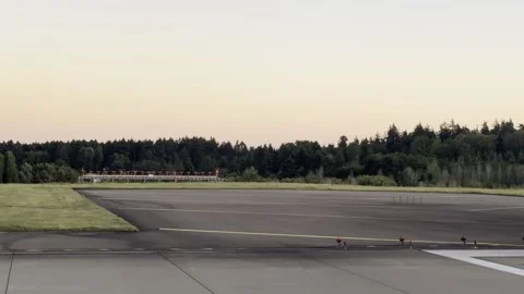 Threshold stripes and rows of edge lights glow at a runway's end in soft dusk Stock Footage 336221084