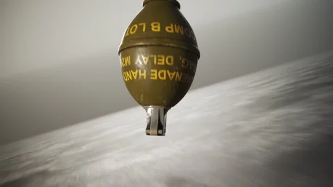 Threw lemon M26 hand grenade rotating on concrete floor with safety pin. 4k HD Stock Footage 119972251