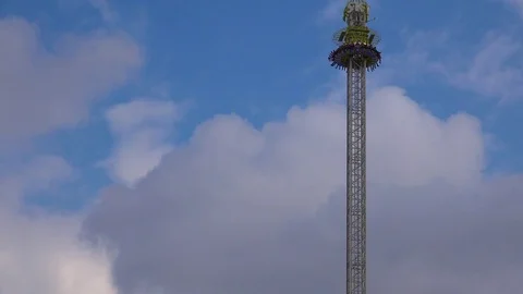 A thrill ride at an amusement park involves a high tower drop. Stockbeeldmateriaal 75685483