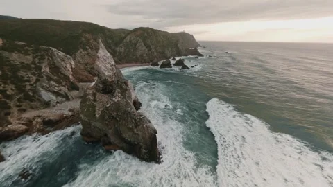 Thrilling FPV drone diving down towering coastal rock formations and flies low Stock Footage 336202004