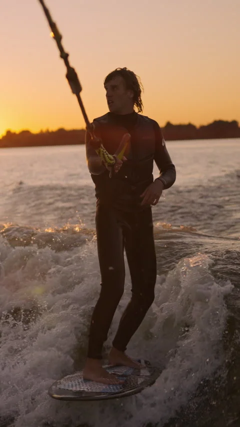 A Thrilling Sunset Surfing Session Captured in Two Frames, Showcasing Skill and Stock Footage 322552508