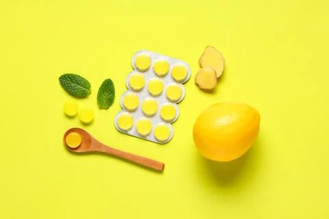 Throat lozenges with ginger root, mint leaves and lemon on yellow background Stock Photos