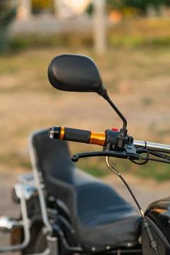 The throttle handle and the mirror on the handlebars of the motorcycle. clo.. Photos