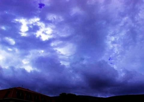 Through the clouds over the sea a ray of sunshine makes its way Stock Photos