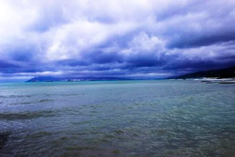 Through the clouds over the sea a ray of sunshine makes its way Stock Photos