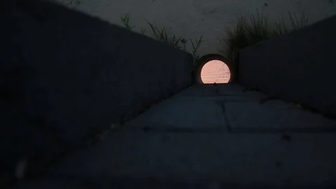 Through the drain pipe you can see the smooth surface of the lake Stock Footage 79060174