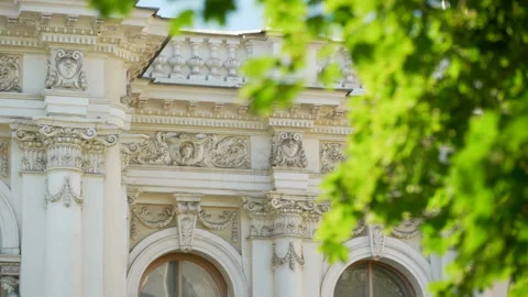 Through the green branches of trees we see historical buildings Stock Footage 119494828