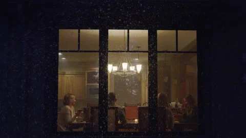 Through Lit up Window Friends Talk During Dinner Party While It Snows Outside Stock Footage 208775177