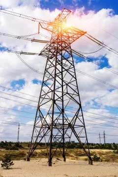 Through a mast of a high voltage cable for electricity, the sun shines Fotos de archivo