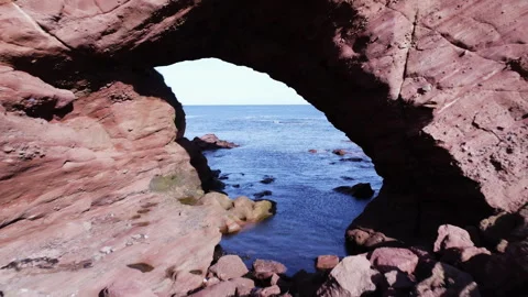 Through a natural arch in Aberdour beach area in Scotland. Stock Footage 322098257