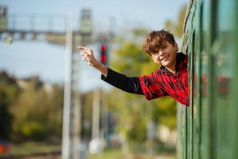 Through the open window of a train car, teenage boy looking out Stock Photos
