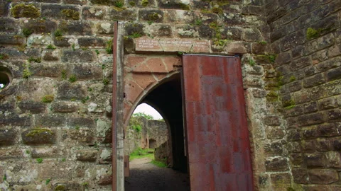 Through the pointed stone archway with a thick metal door an inner courtyard Stock Footage 309358761