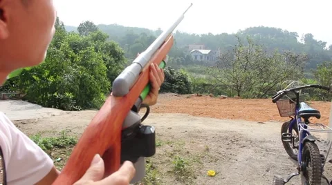 Through shoulder view of a man shooting a gun, sporting gun Stock Footage 49699820