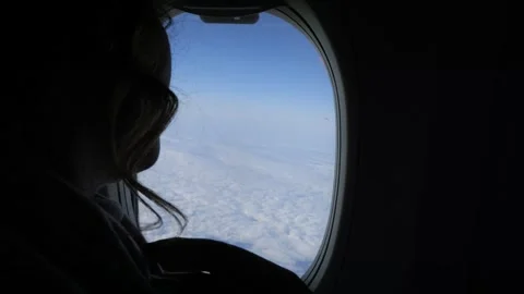 Through the silhouette of a passenger, enjoy the view of clouds and sky from an Stock Footage 276903702