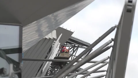 Through web of metallic beams skilled worker shapes facade Stock Footage 316094311