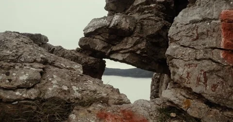 Through a window into a mountain cliff is seen as the sea mist Stock Footage 53565272