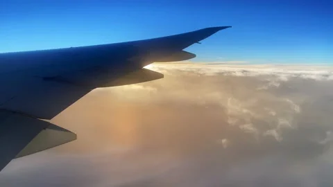 Through the window of the plane, the sea of clouds turned golden by the setting Stock Footage 170938622