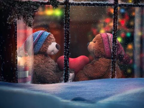 Through the window in the snow looking at plush bears holding a heart. Christ Stock Photos