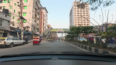 Through the windshield, the cityscape of Mirpur unspools in a continuous Stock Footage 321601623
