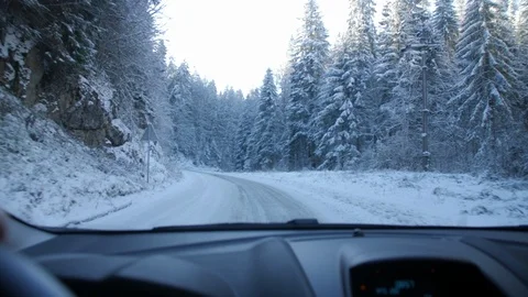 Through Windshield Shot of Driving on Snow Covered Forest Road During Winter Stock Footage 90077241