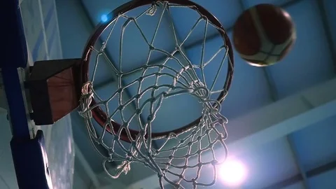 Throw a ball into the basketball ring against the backdrop of searchlights. Slow Stock Footage 84832736
