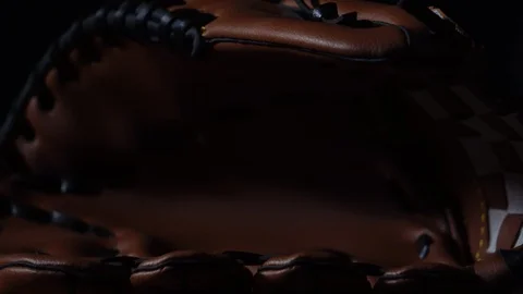 Throw a baseball with a baseball glove, put in a dark light Stock Footage 107734000