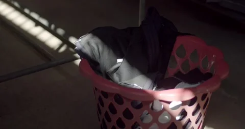 Throw clothes into the basket.Reflection of the sunlight in the evening. Stock Footage 251292726