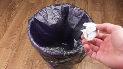 Throw the crumpled piece of paper into the trash bin.Waste disposal Stock Footage 253225089