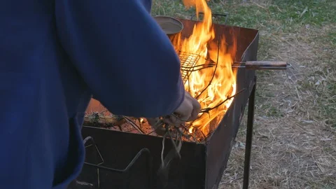 Throw firewood into the fire to pre-prepare for barbecue preparation Stock Footage 121689307